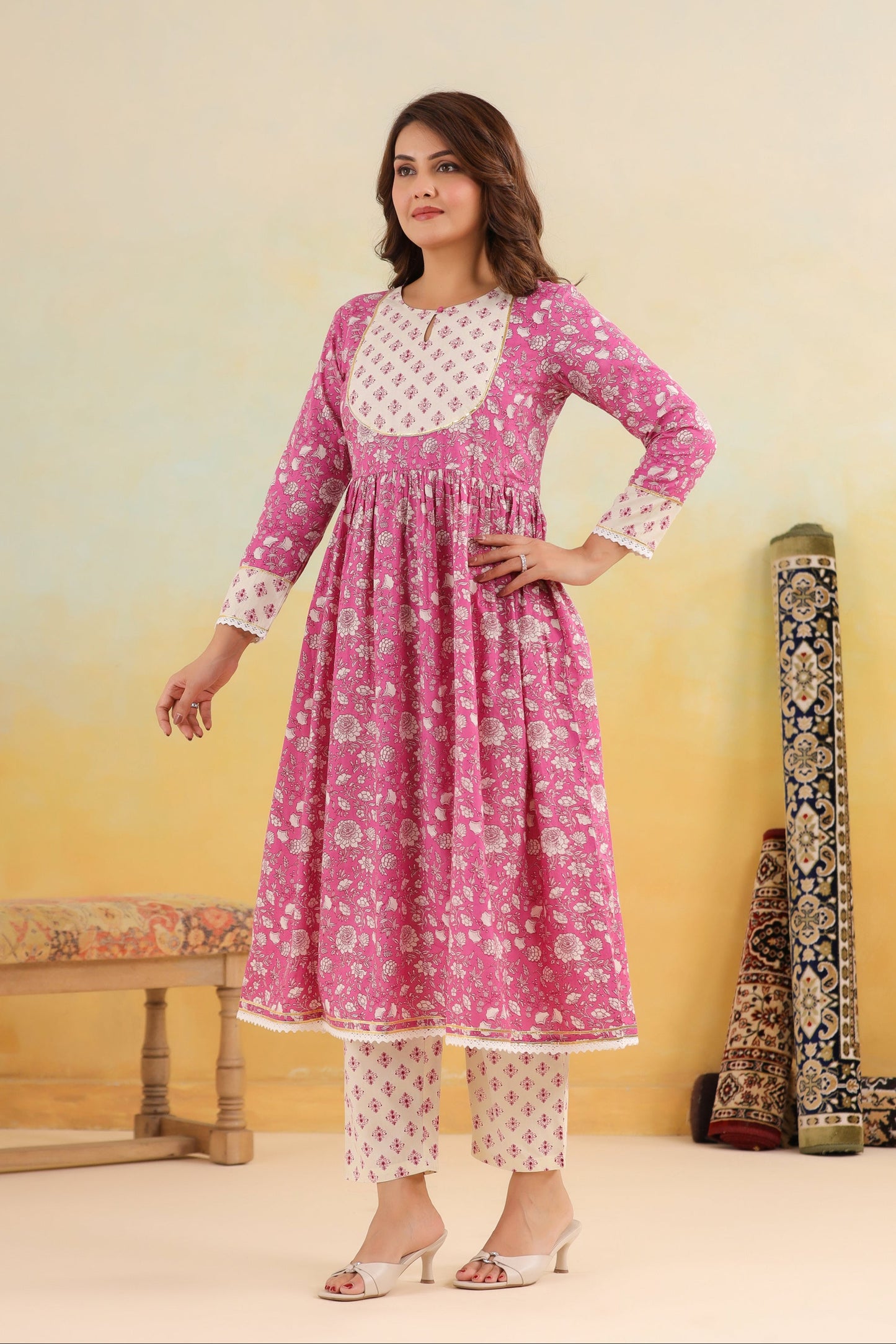 Woman wearing a pink and white traditional outfit with a yellow gradient background