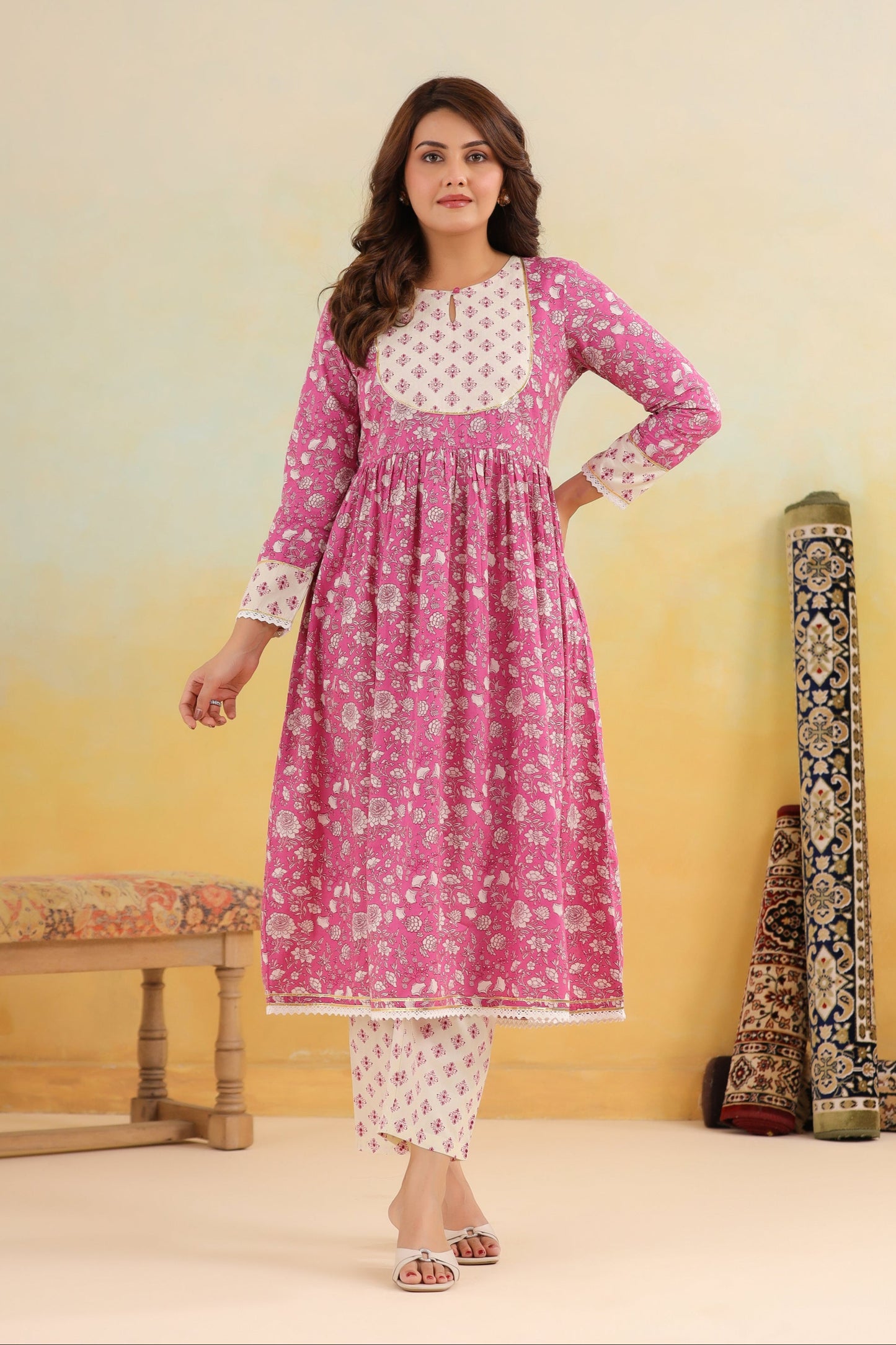 Woman wearing a pink and white traditional outfit with a yellow background