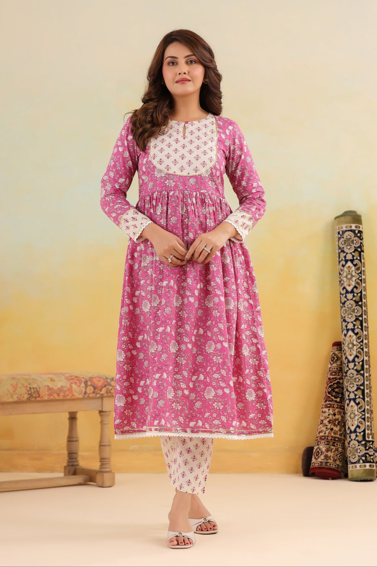 Woman wearing a pink and white traditional outfit with a yellow and beige gradient background