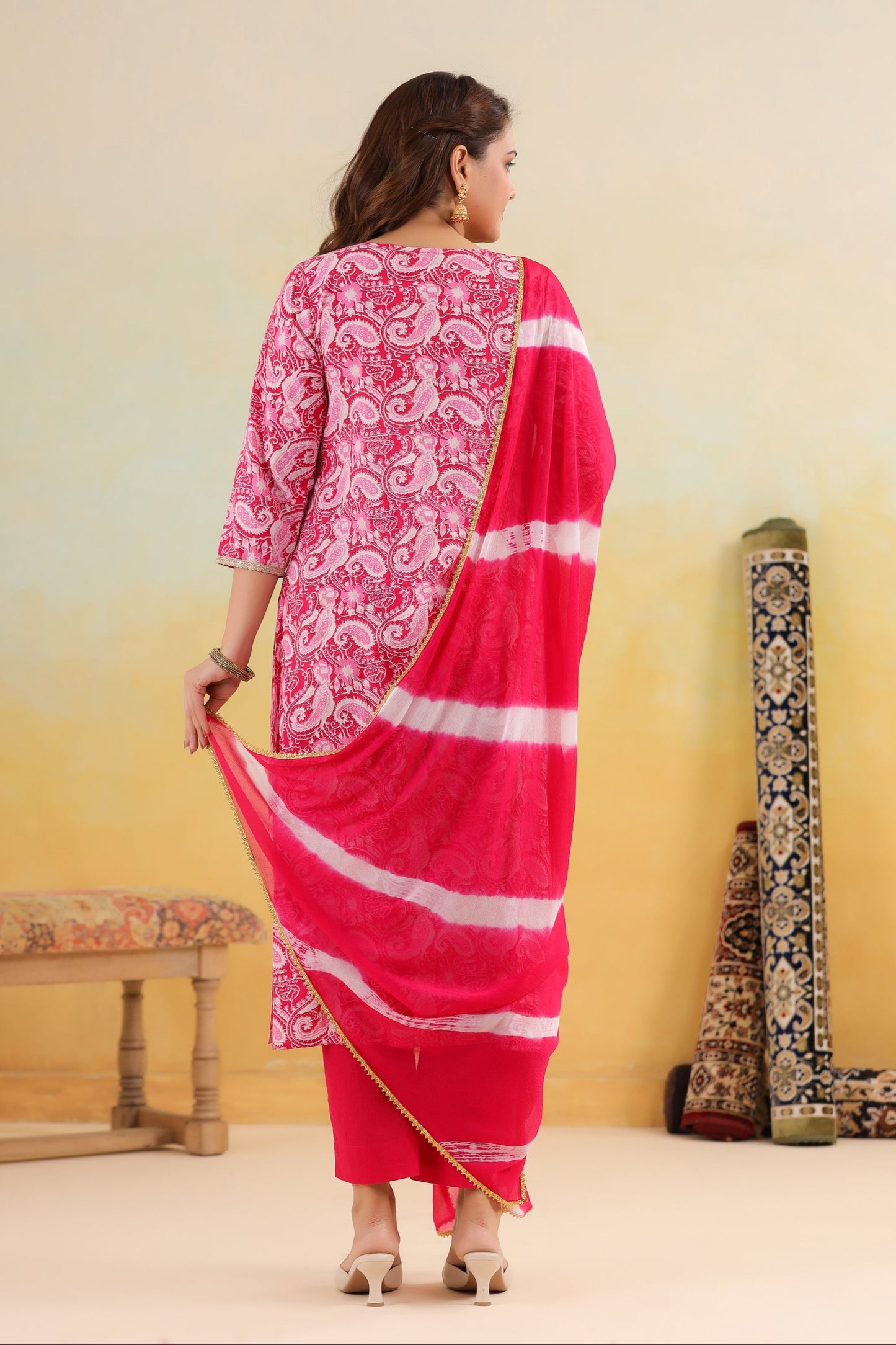 Woman in a pink traditional outfit with a yellow gradient background