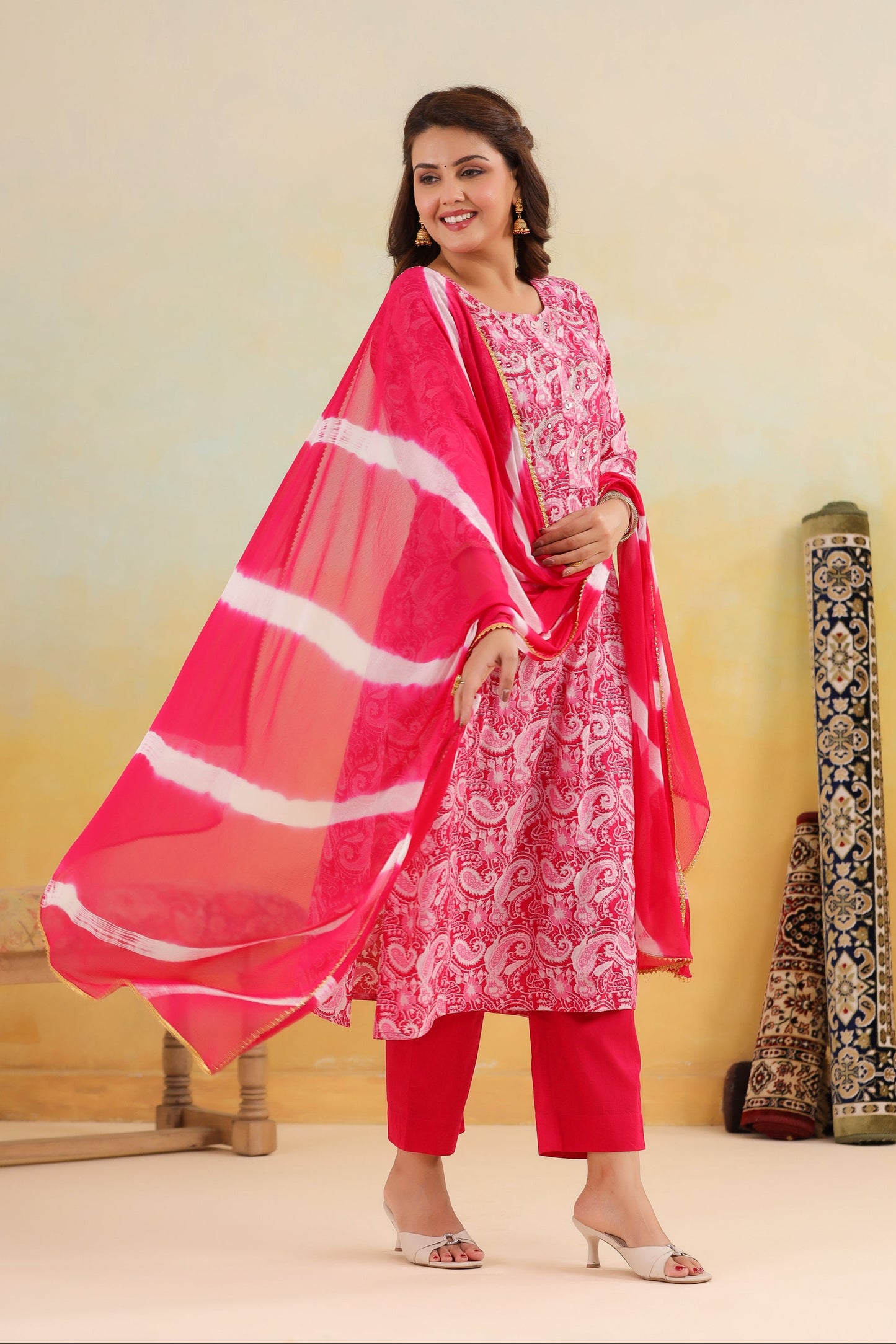Woman wearing a pink traditional outfit with a white border against a plain background
