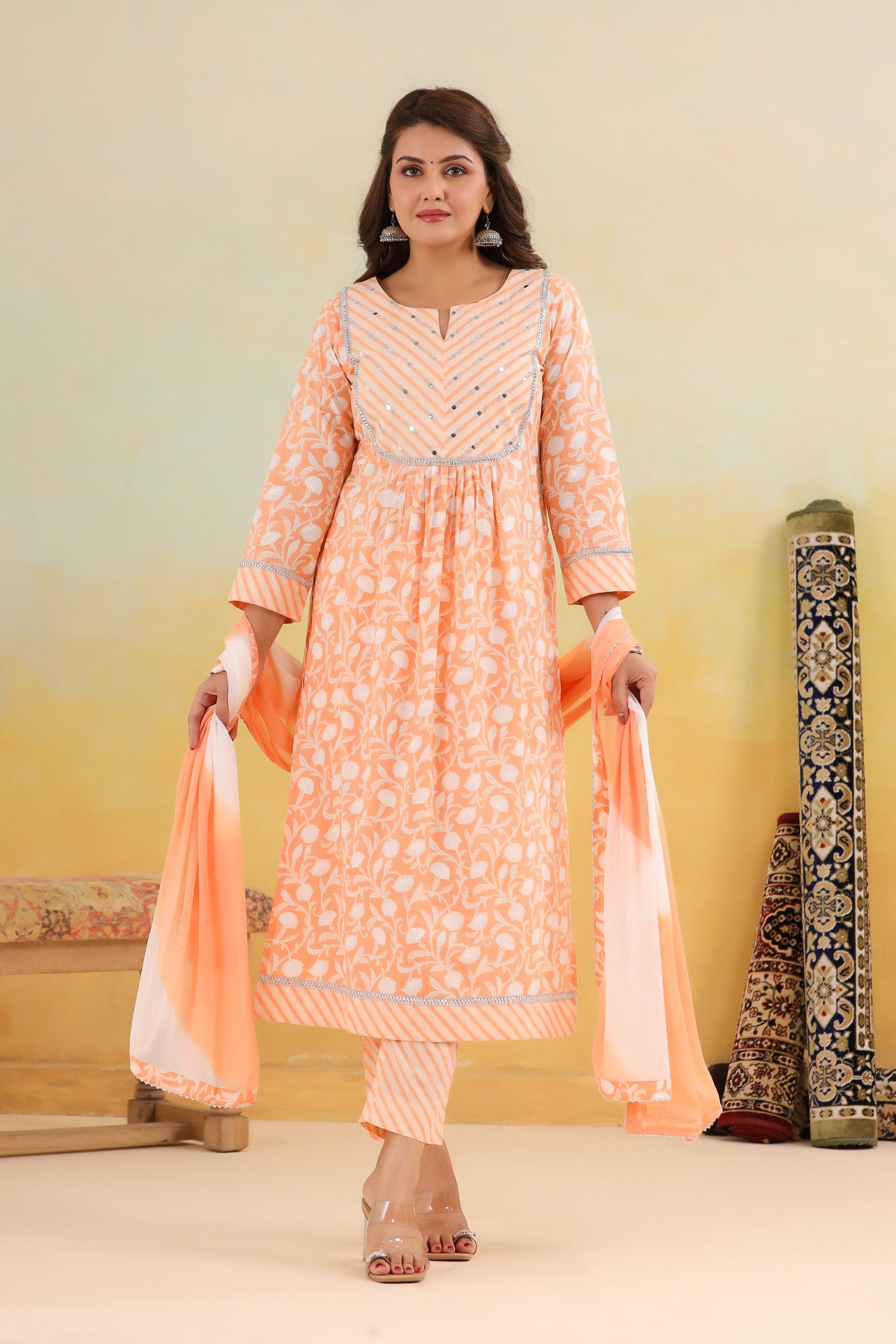 Woman wearing a peach-colored traditional outfit with a plain background