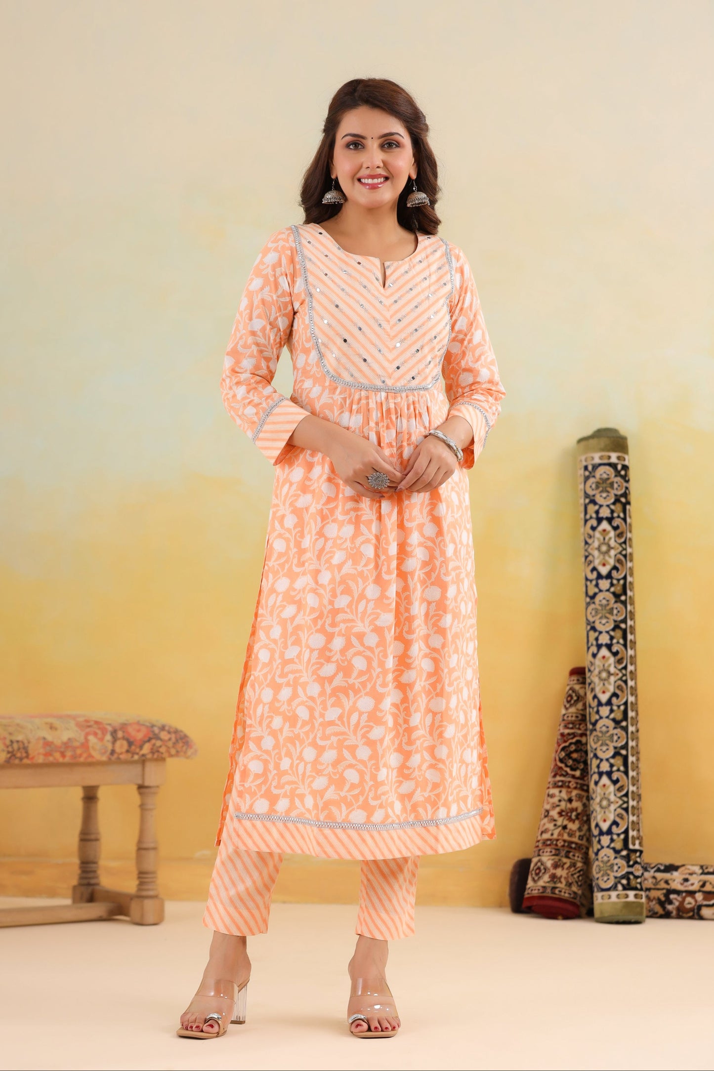 Woman wearing a peach-colored traditional outfit with a yellow background