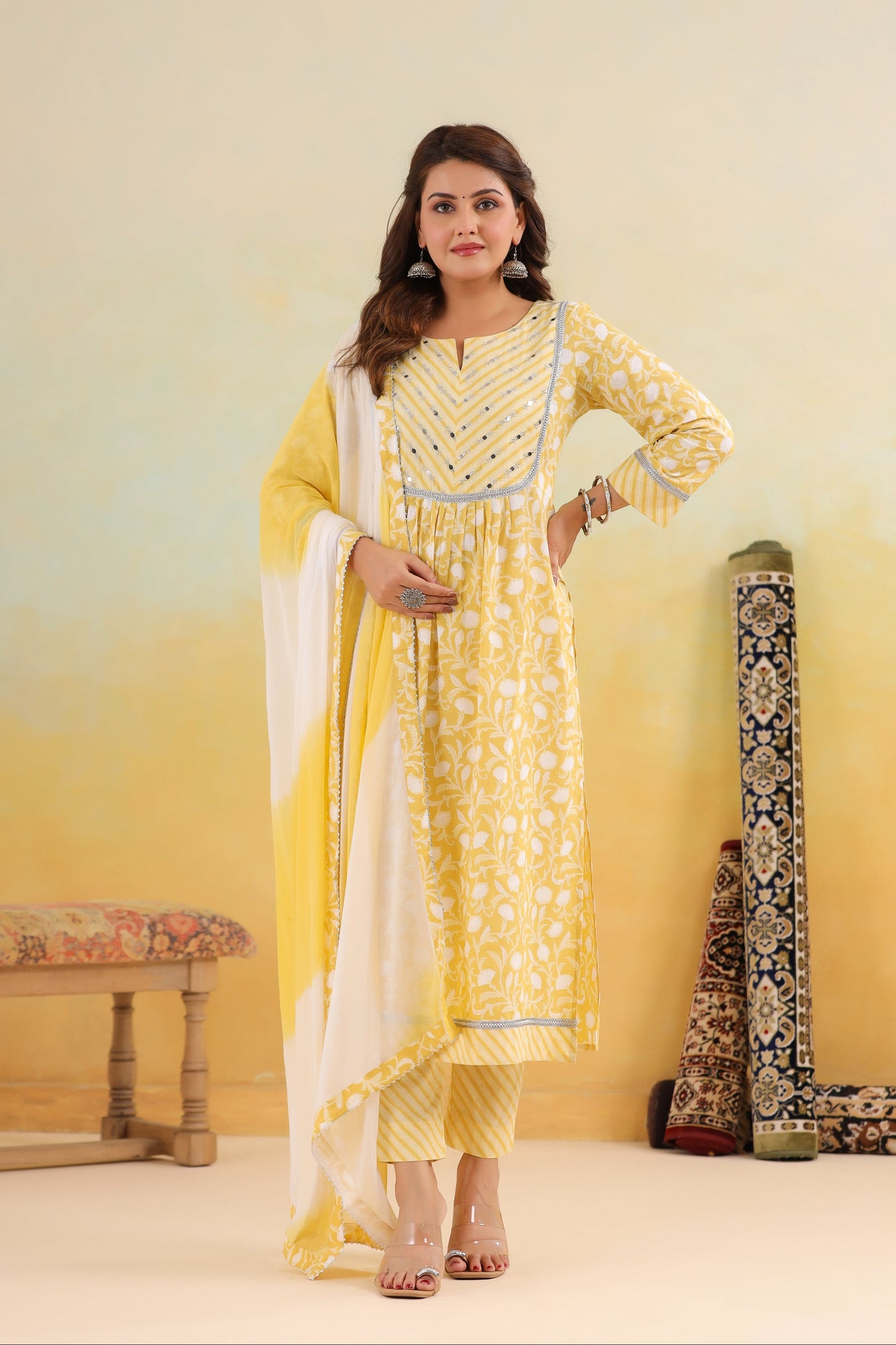 Woman in a yellow and white traditional outfit with a white background