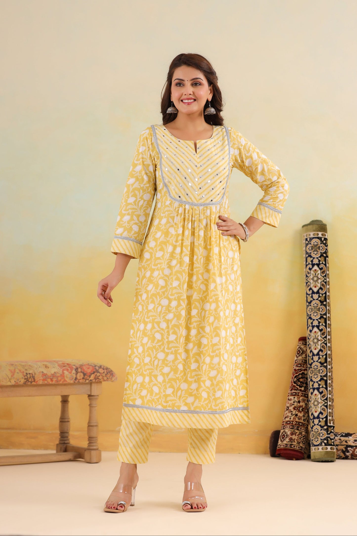 Woman wearing a yellow kurta with a white pattern against a light yellow background