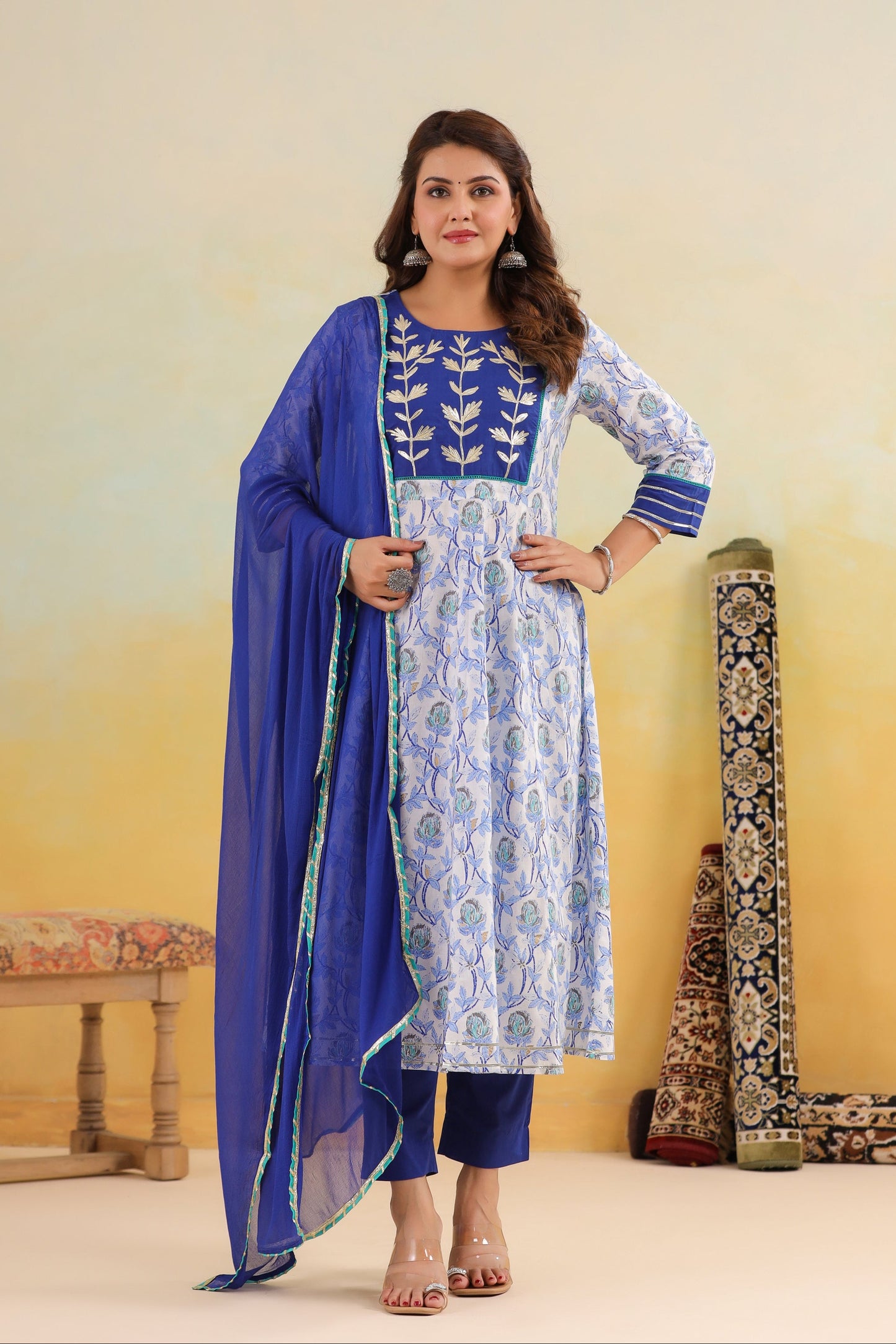 Woman wearing a blue and white traditional outfit with a yellow background