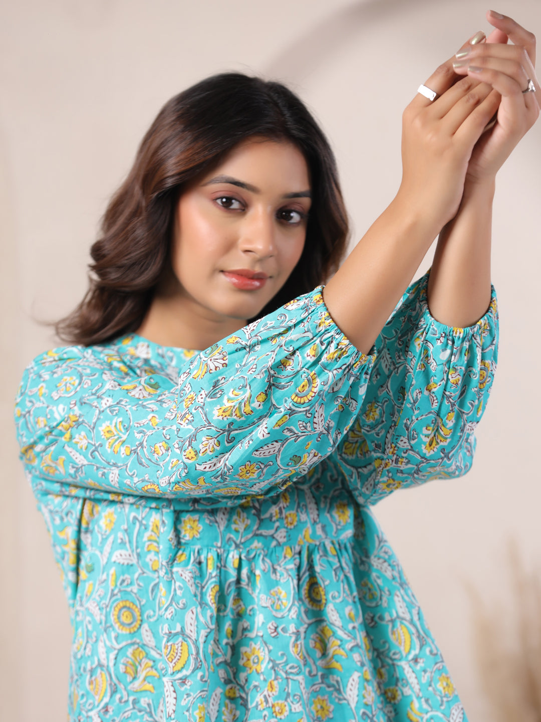 Woman in turquoise floral print cotton kurta with puff sleeves, elegant daily wear