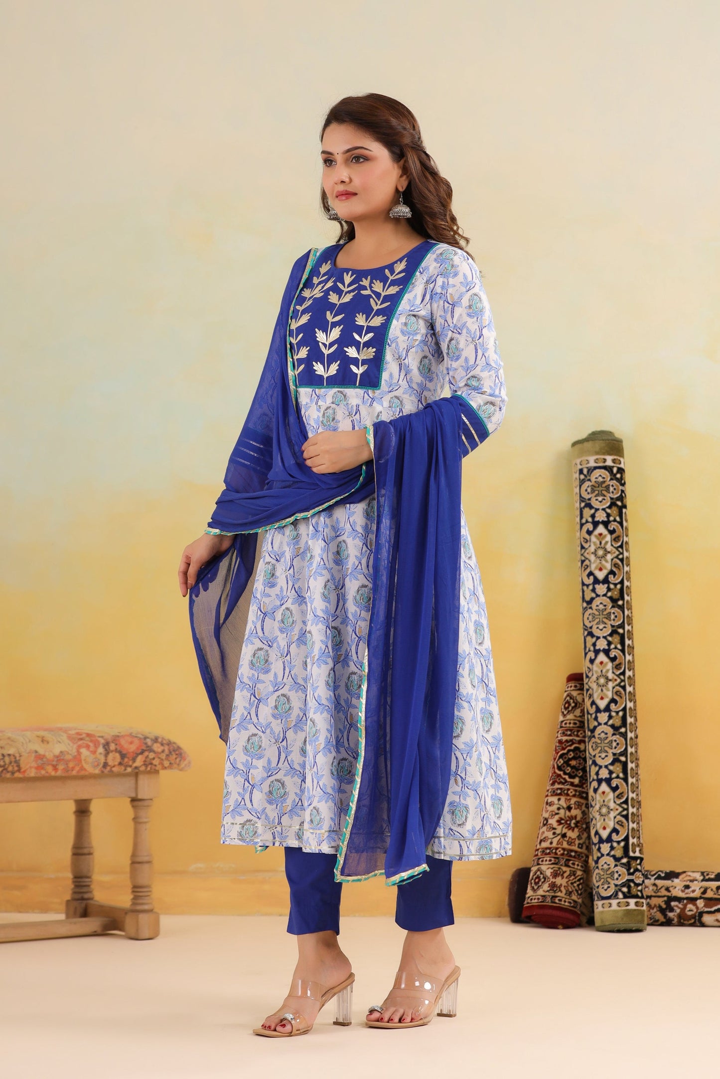 Woman wearing a blue and white traditional outfit with a yellow background