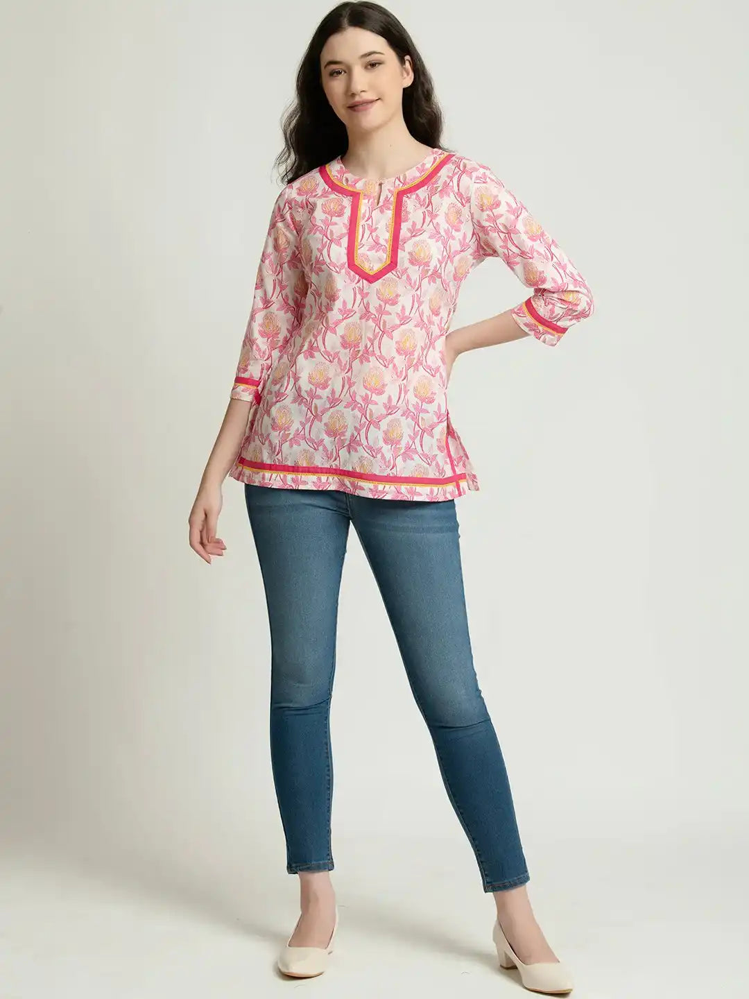 Pink floral printed cotton kurta with contrast trim, paired with blue jeans for casual wear