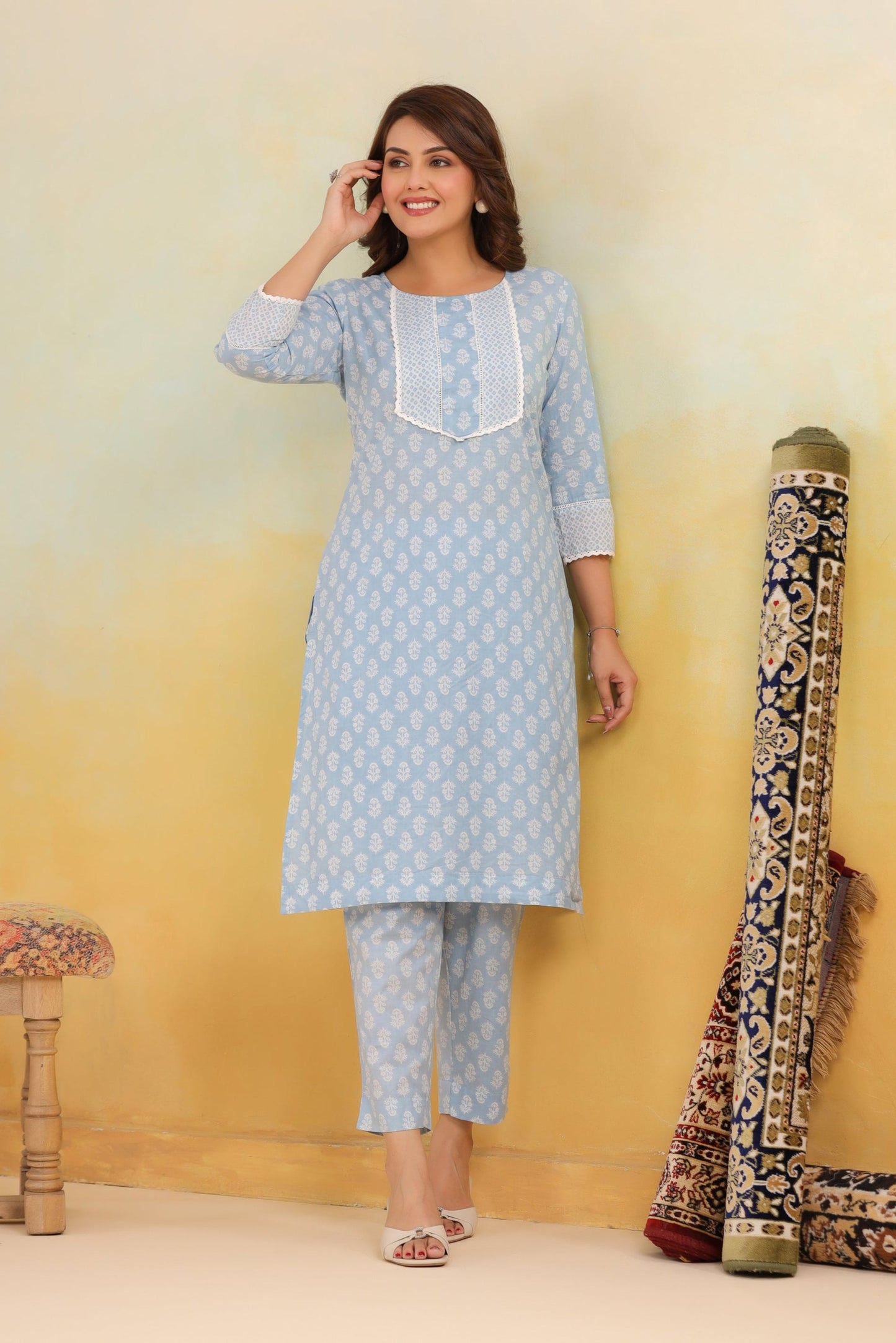 Woman wearing a light blue kurta with white embroidery against a yellow background