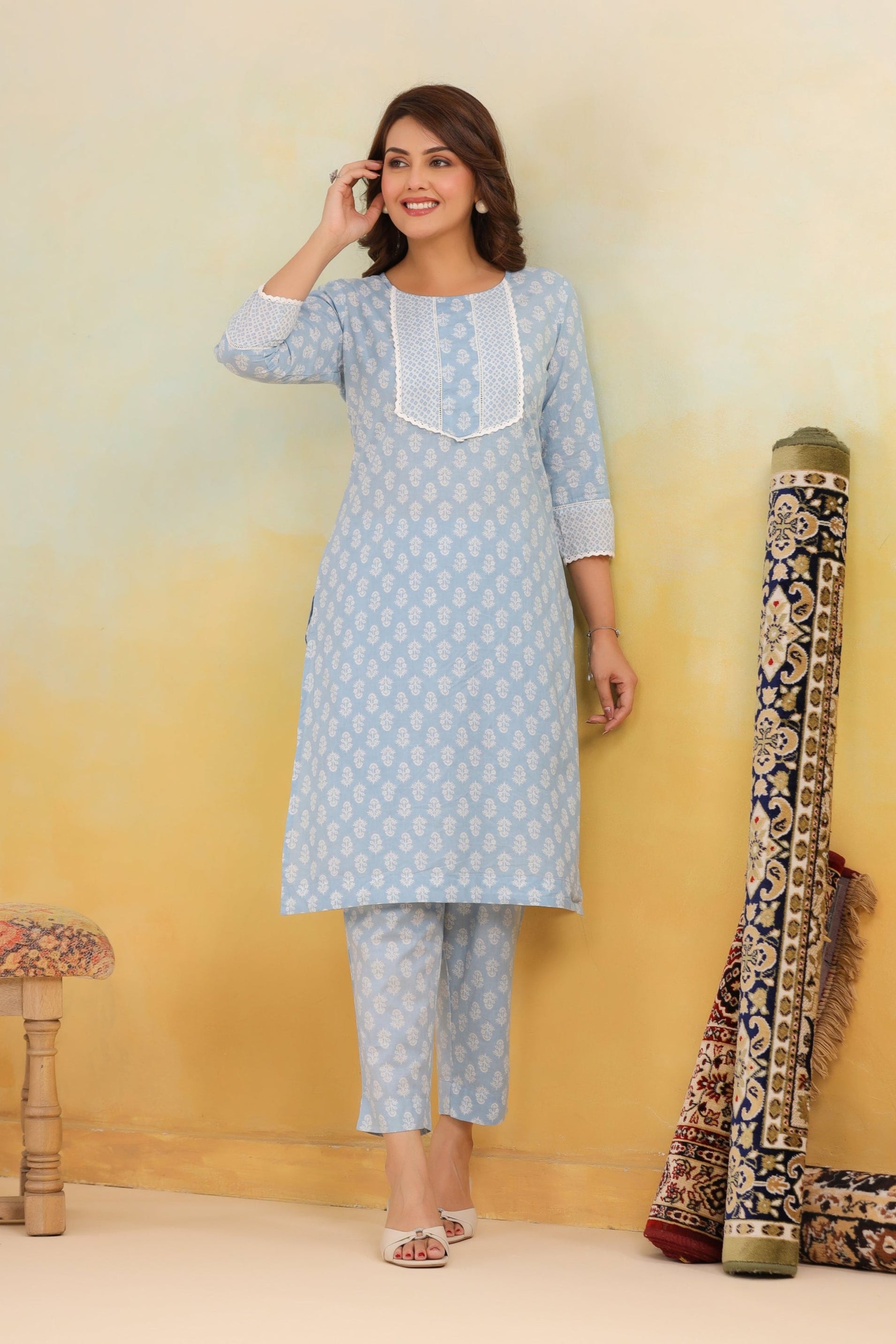 Woman wearing a light blue kurta with white embroidery against a yellow background