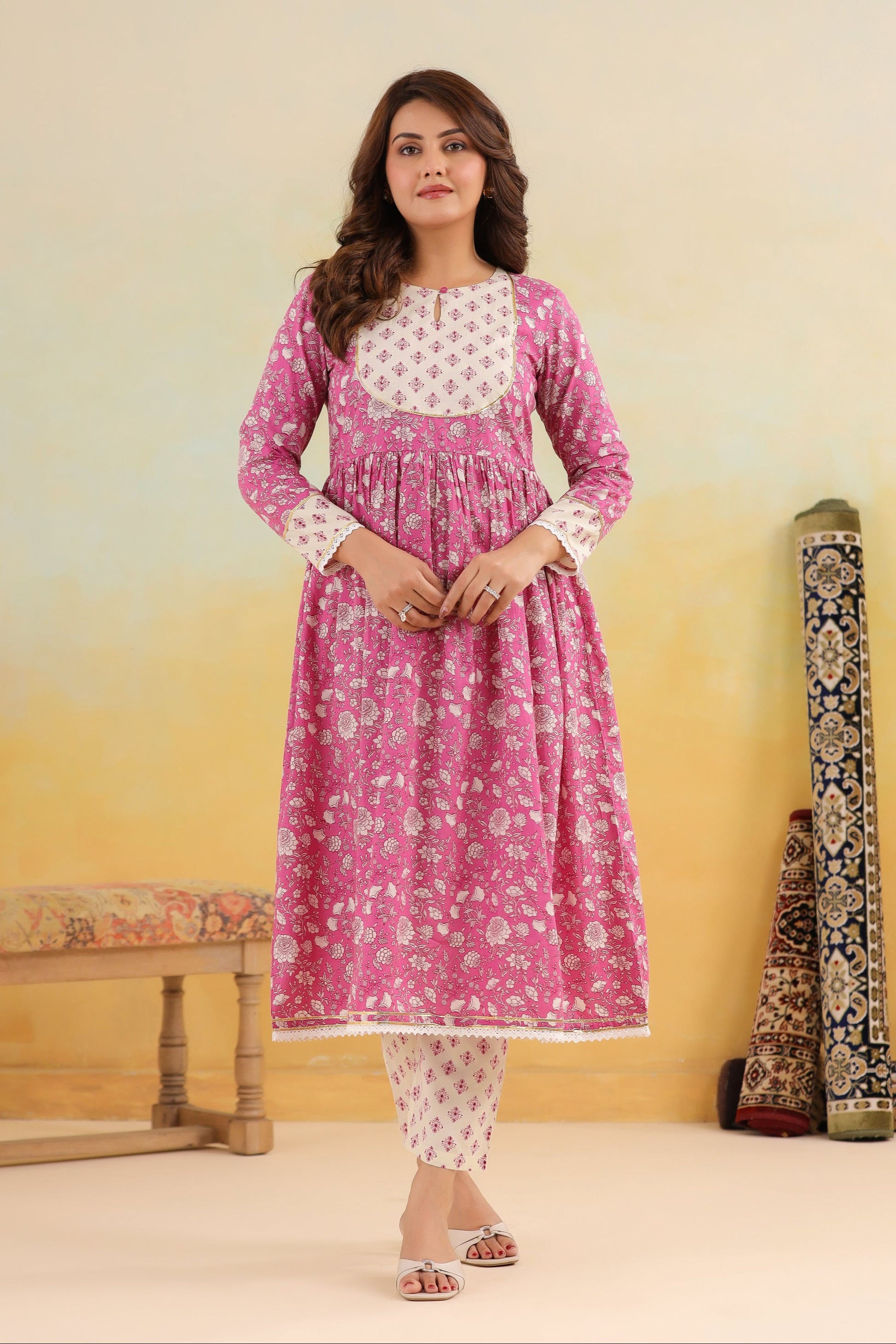 Woman wearing a pink and white traditional outfit with a yellow and beige gradient background
