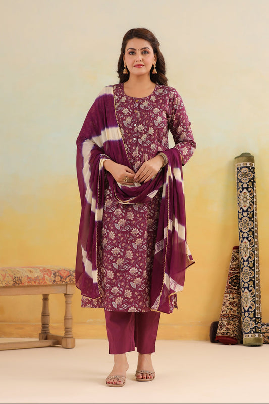 Woman wearing a purple floral outfit with a matching shawl against a yellow background