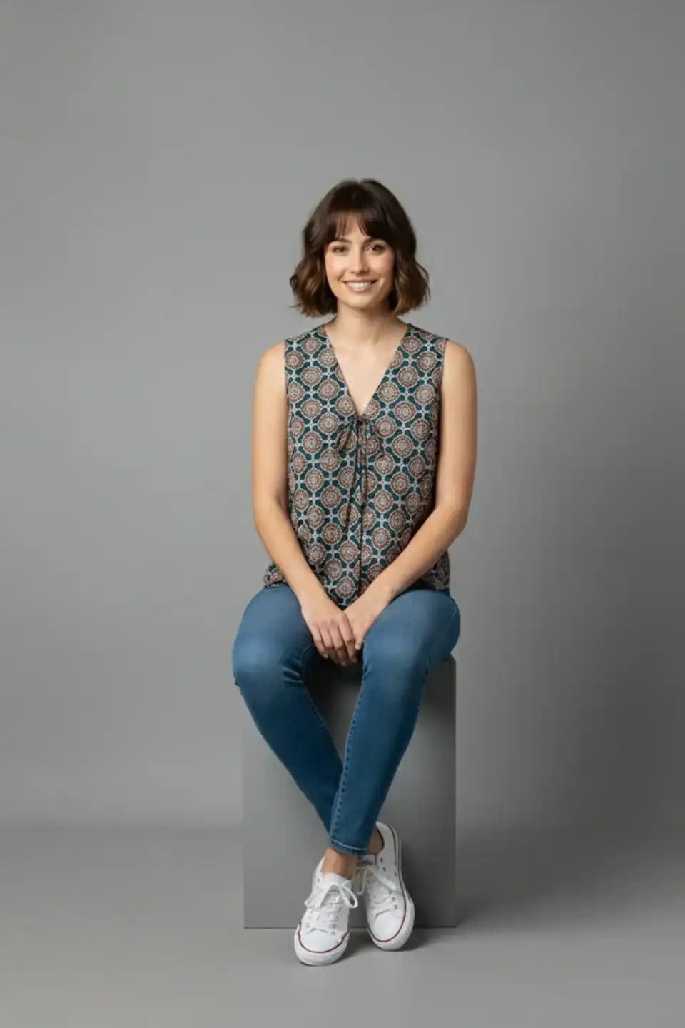 Woman in sleeveless printed top and jeans, casual daily wear outfit