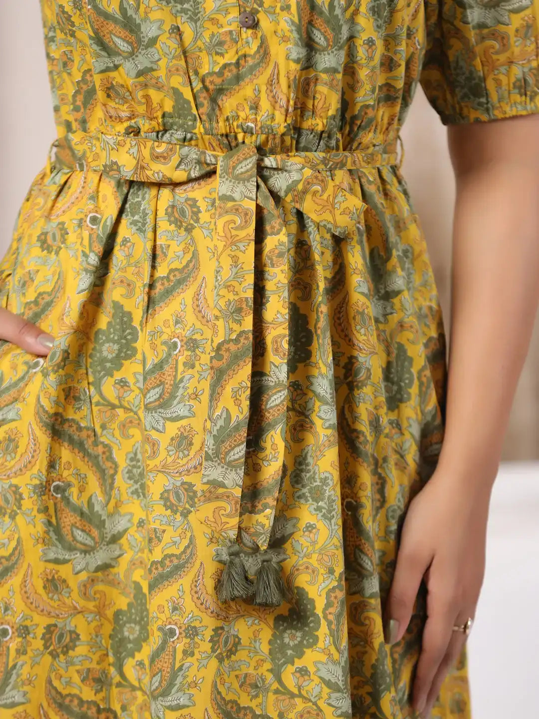 Yellow cotton kurta with green paisley print, tie waist, and tassel details for women