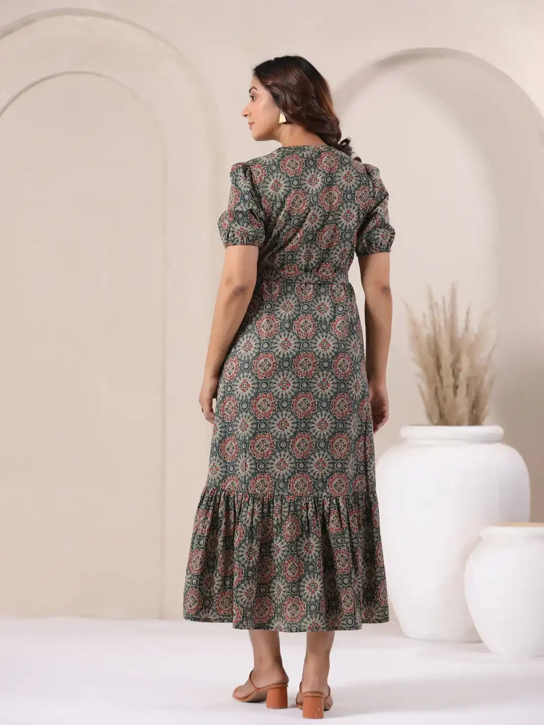 Woman wearing green floral print cotton kurta dress with puff sleeves and tiered hem, perfect for daily wear or celebrations