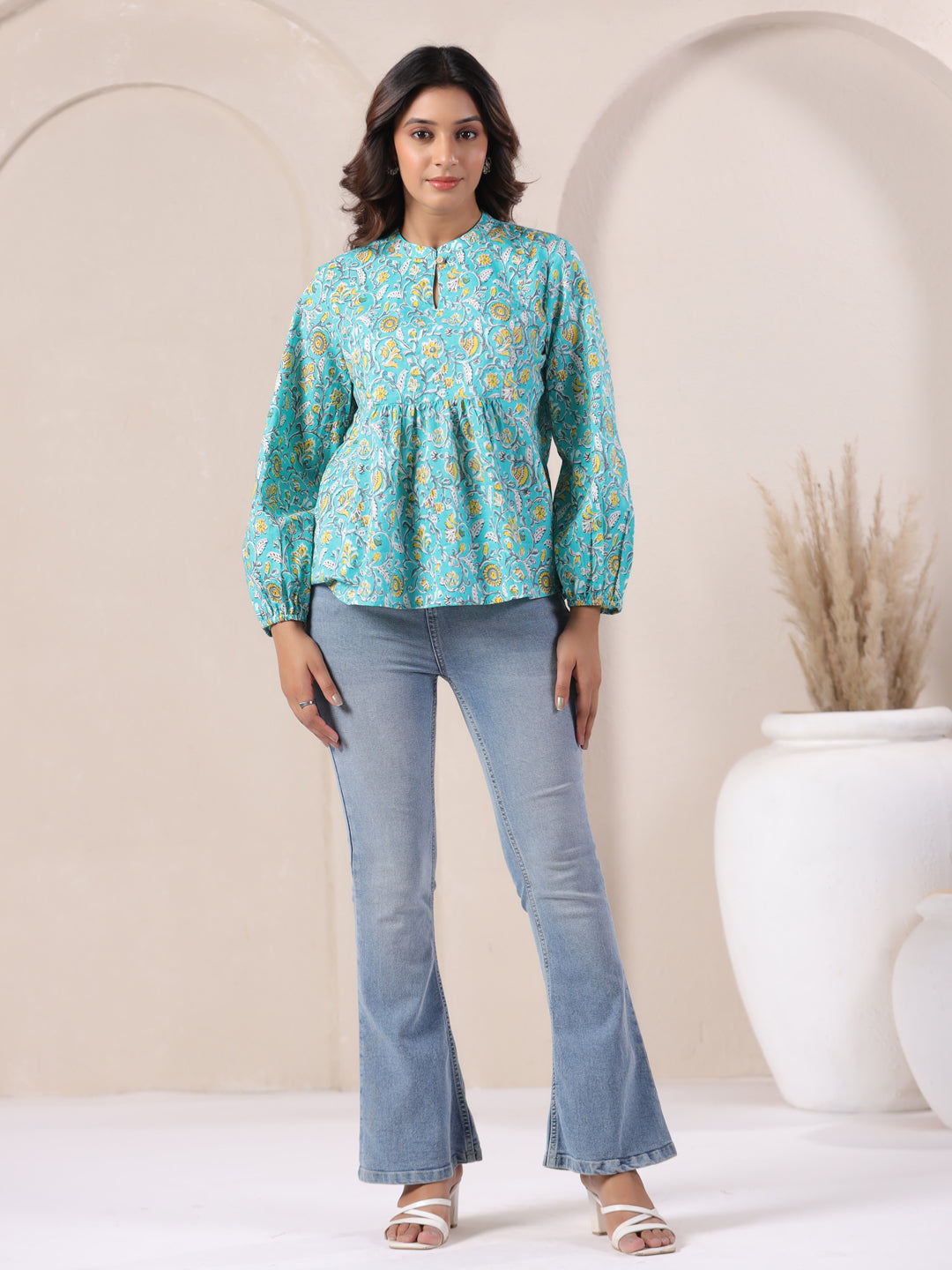 Turquoise floral print cotton top with puff sleeves, paired with flared jeans for casual wear