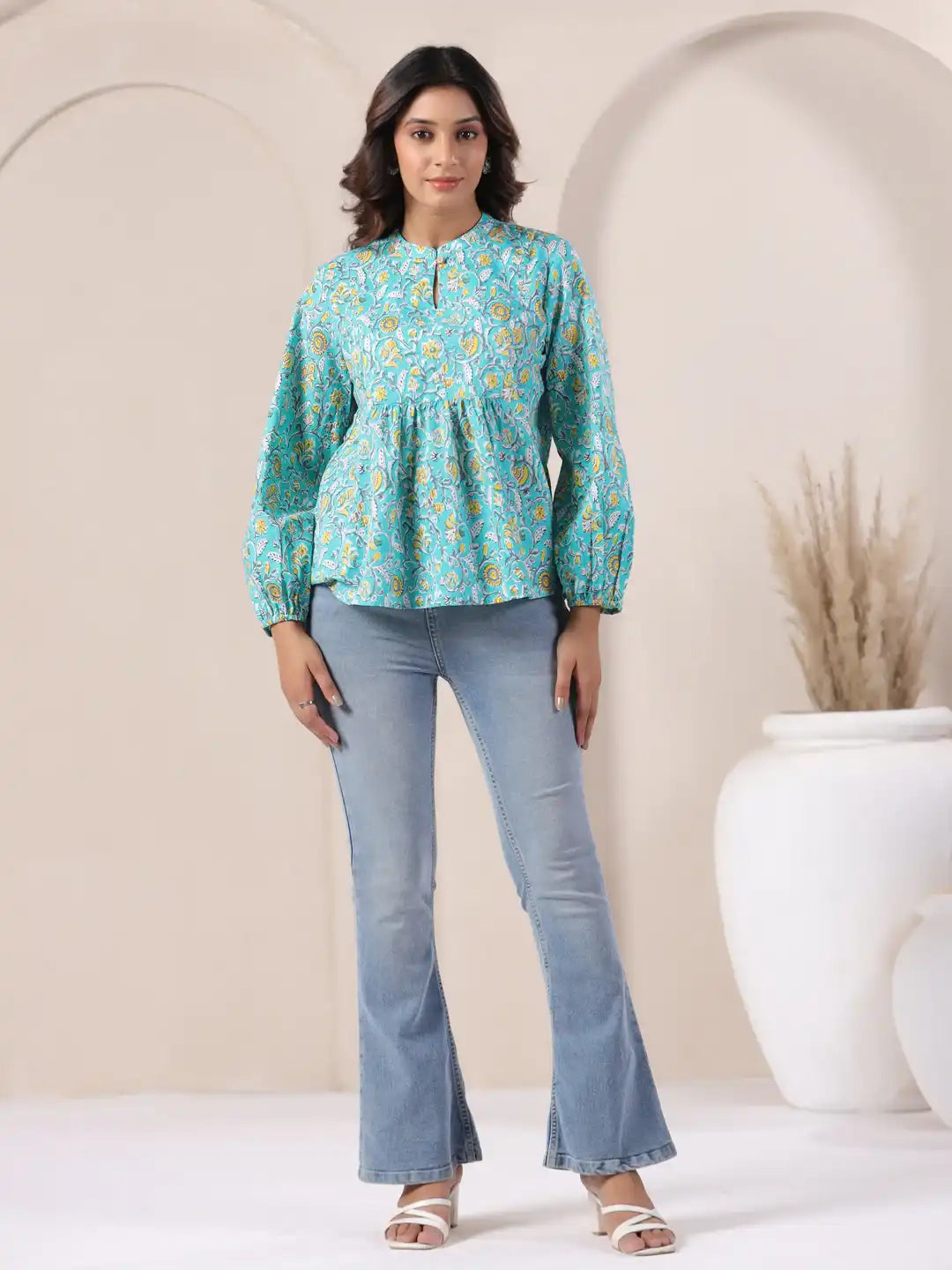 Turquoise floral print cotton top with puff sleeves, paired with flared jeans for casual wear
