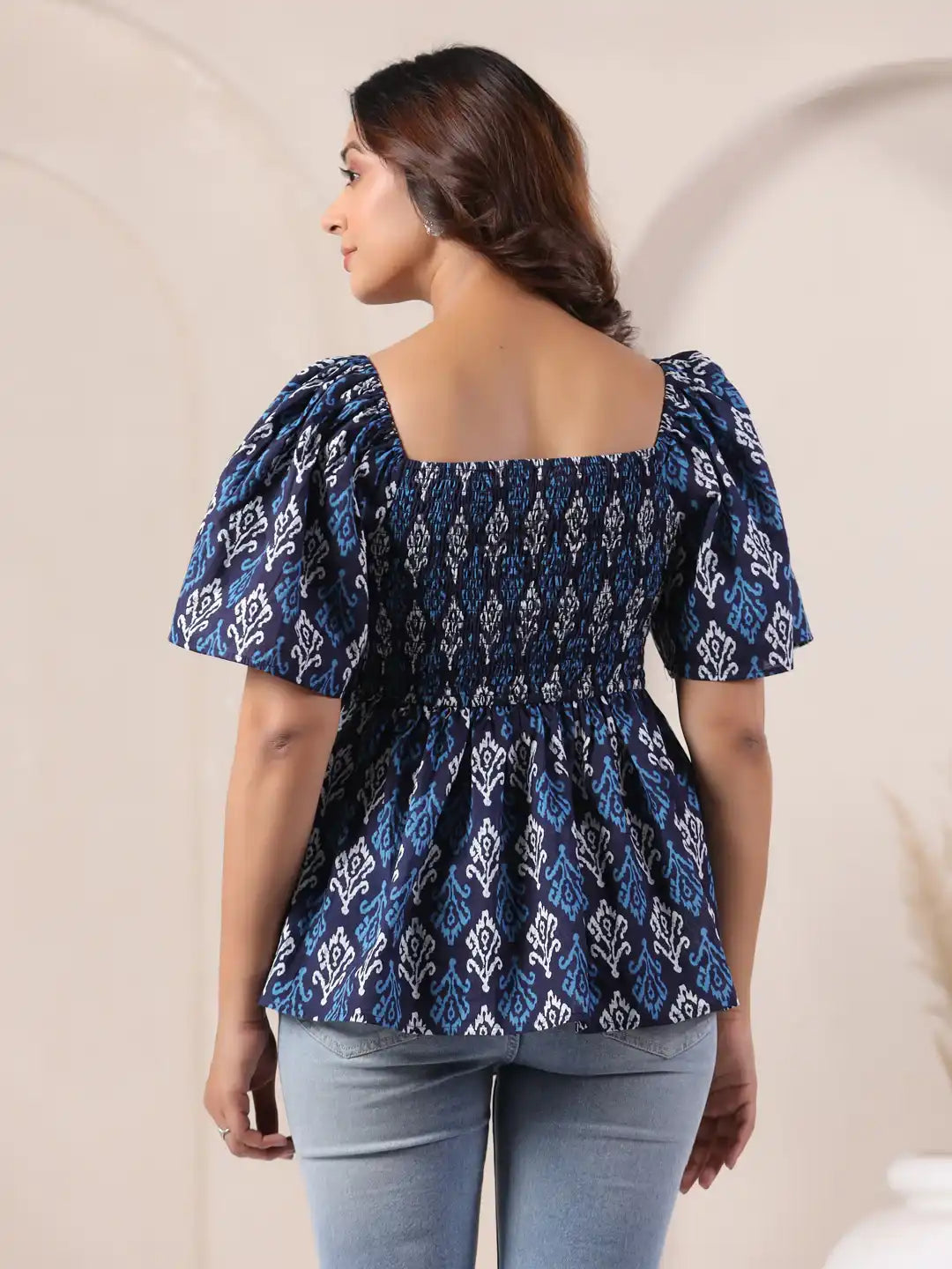 Blue and white patterned cotton top with puff sleeves and square back, paired with jeans