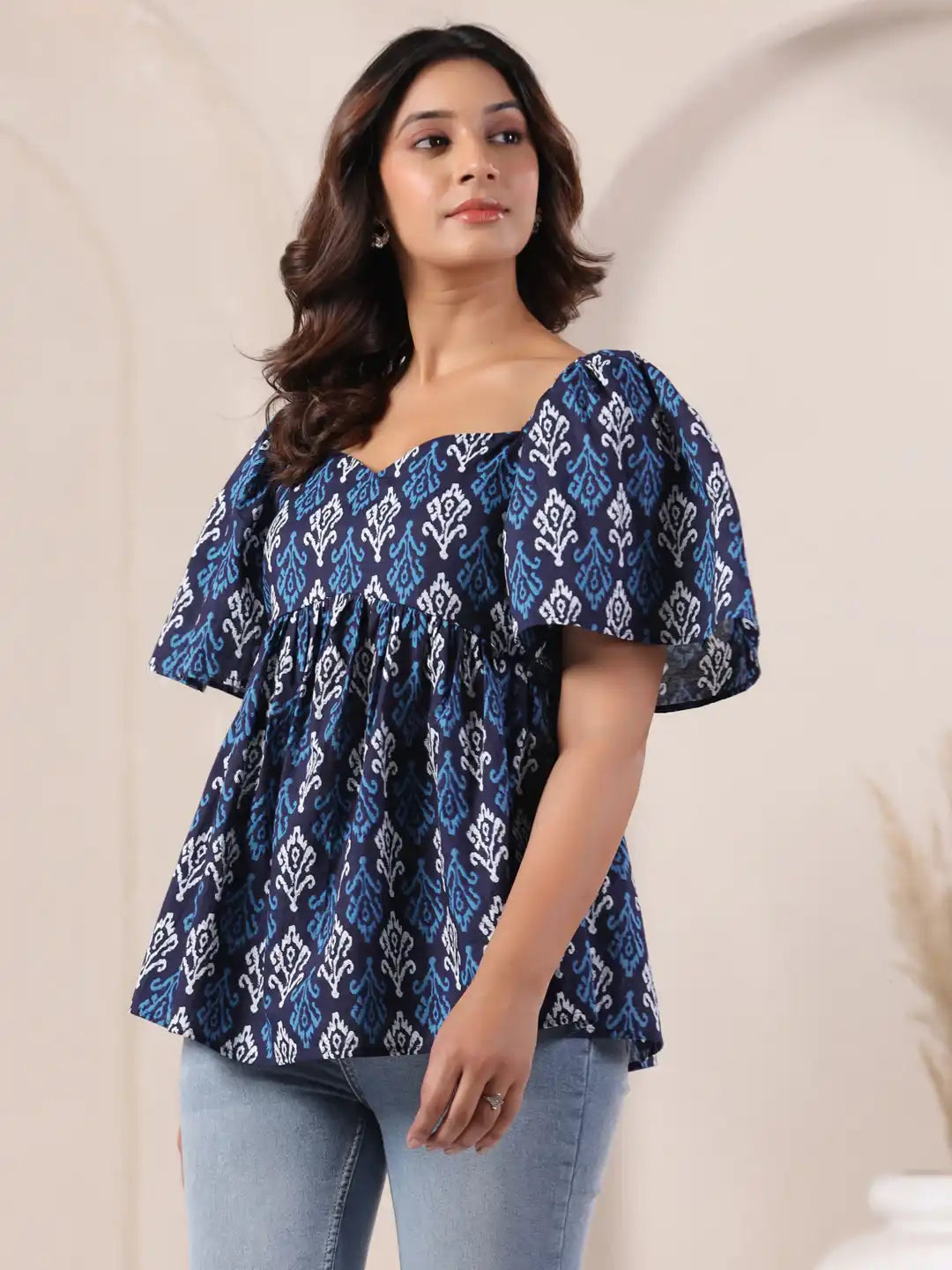 Blue and white printed cotton top with puff sleeves, paired with jeans for casual wear