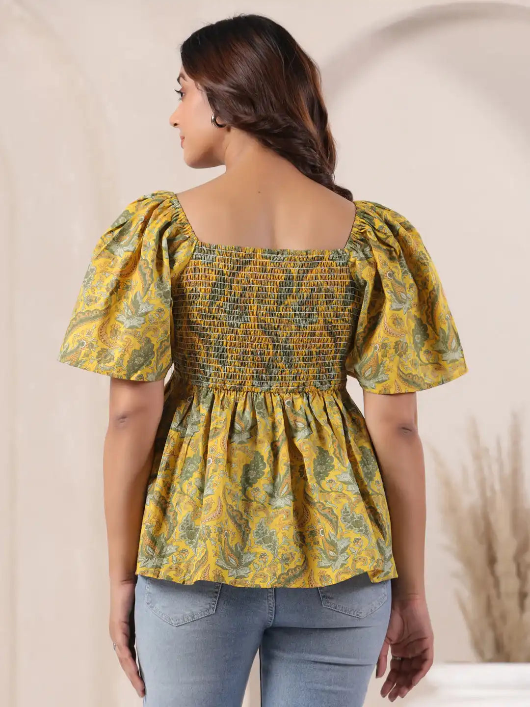 Yellow floral print peplum top with puff sleeves and smocked back, paired with jeans for casual wear