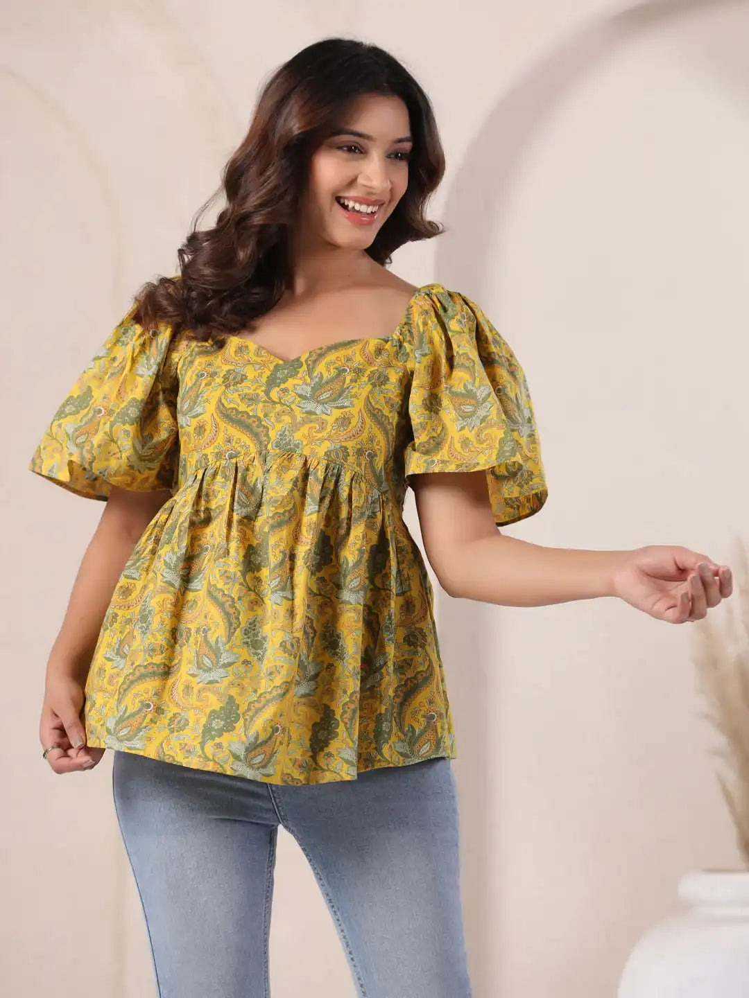 Yellow paisley print peplum top with puff sleeves, paired with jeans for casual wear