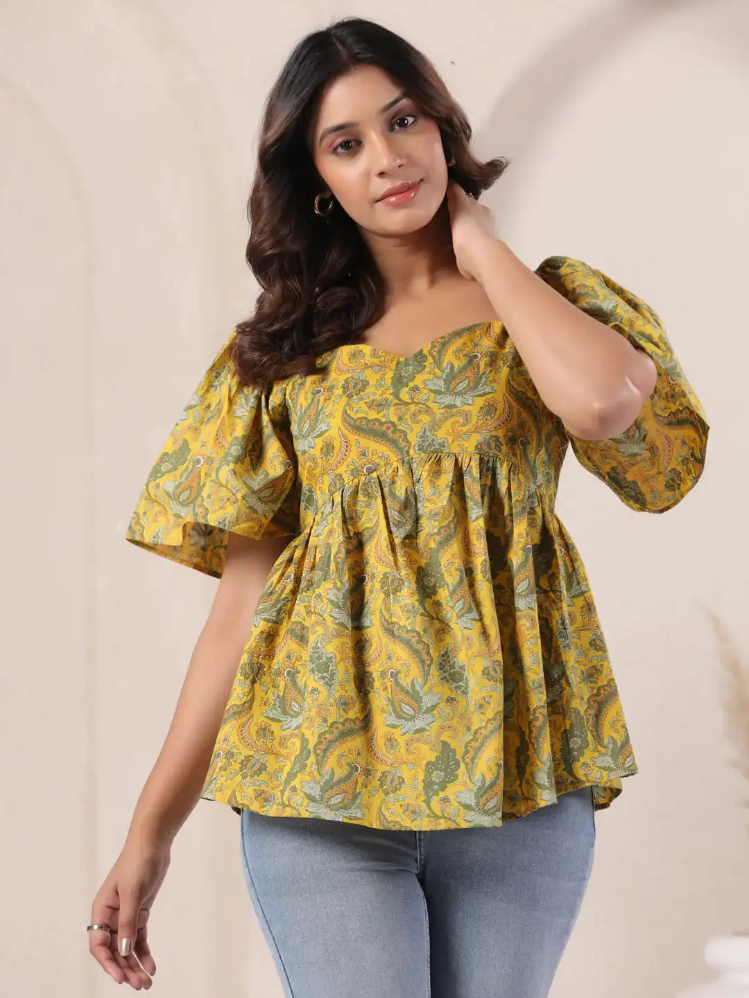 Yellow paisley print peplum top with puff sleeves, paired with jeans for casual wear