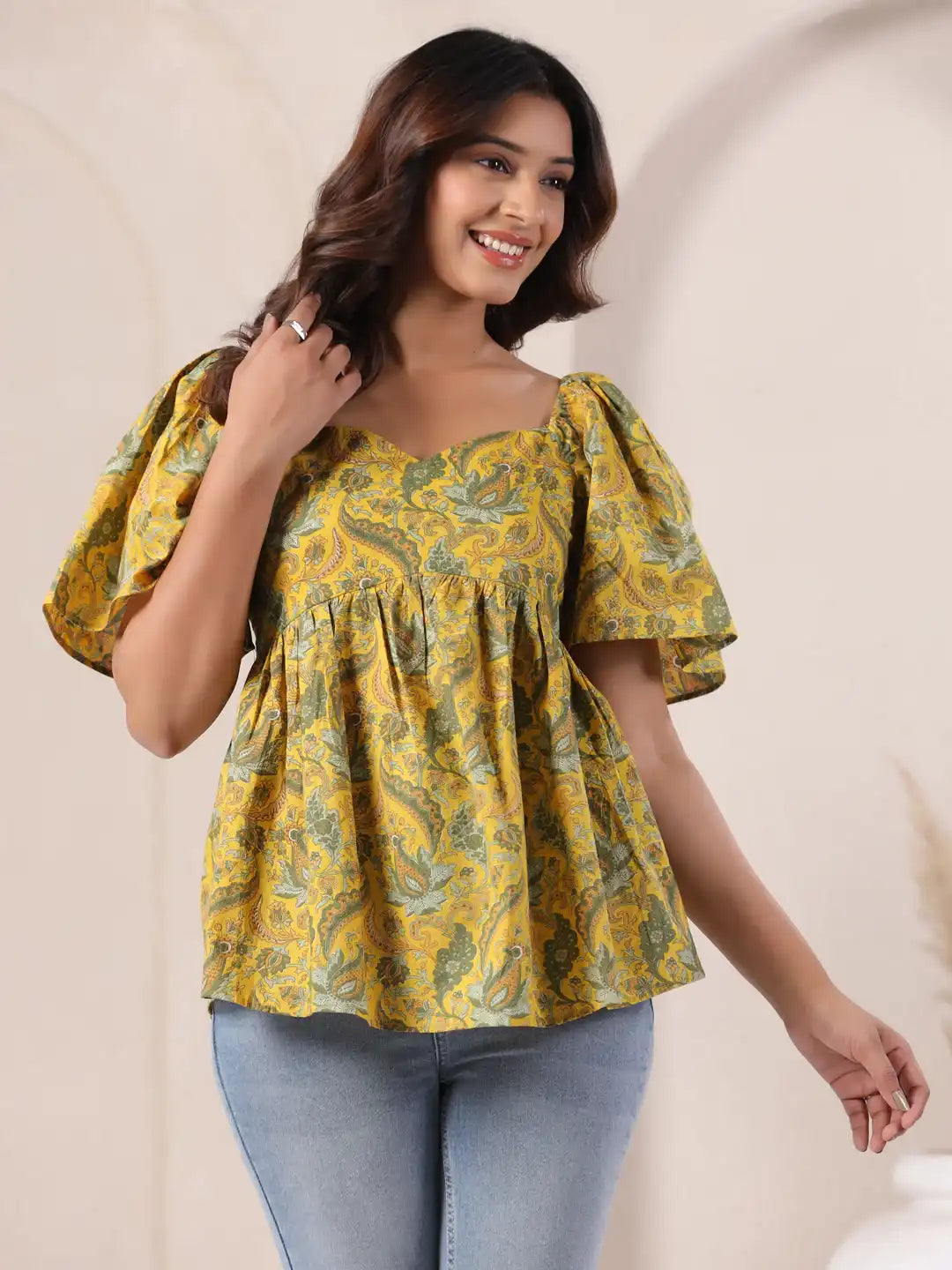Yellow paisley print peplum top with puff sleeves, paired with jeans for casual wear