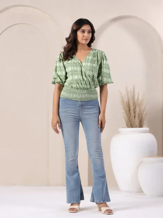 Green printed V-neck top with puff sleeves paired with flared jeans for women's casual wear