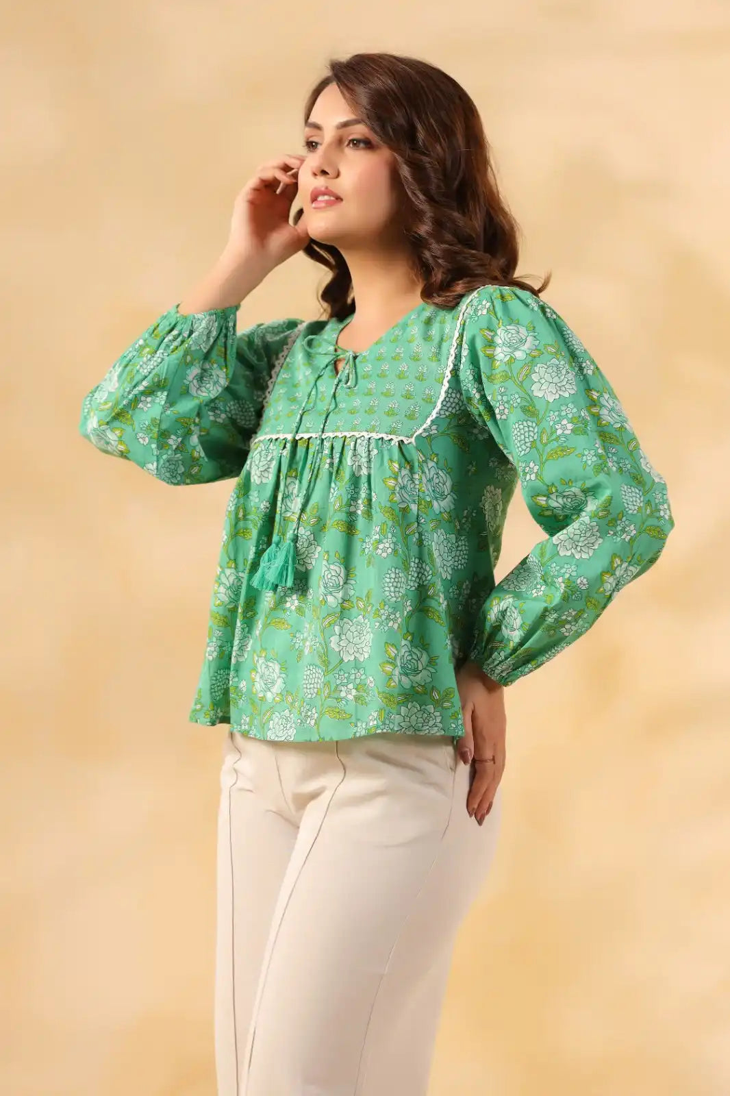 Green floral print cotton kurta with puff sleeves and tassel detail, paired with white pants for women