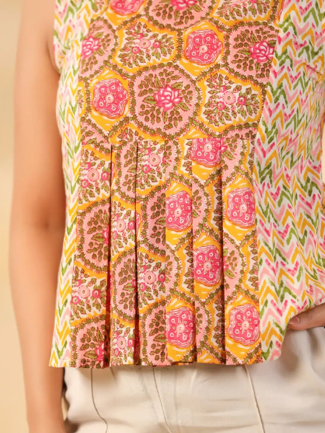 Women's cotton kurta with vibrant floral and geometric print, pleated hem, and sleeveless design