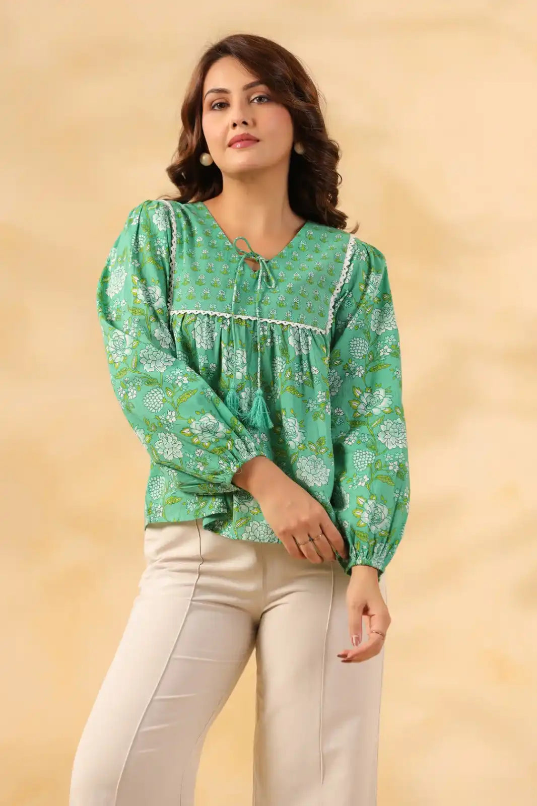 Green floral print cotton kurta with puff sleeves and tassel tie, paired with cream pants for women