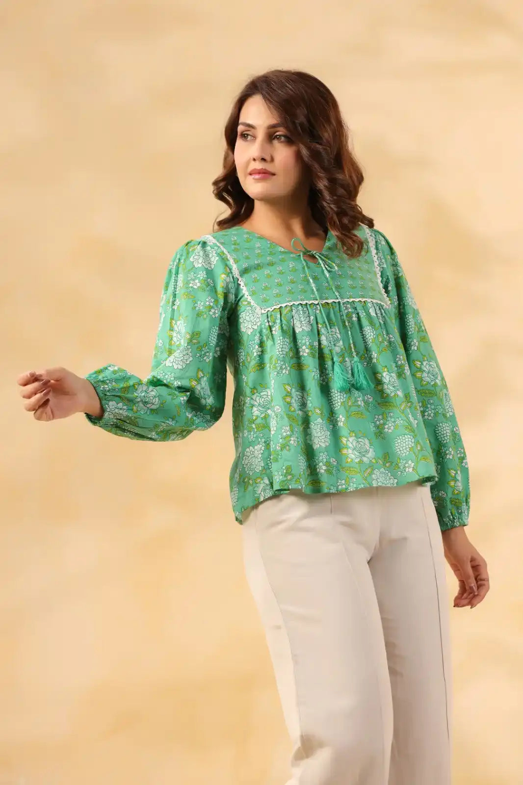 Green floral print cotton kurta with lace trim and tassels, paired with white pants for women's casual wear