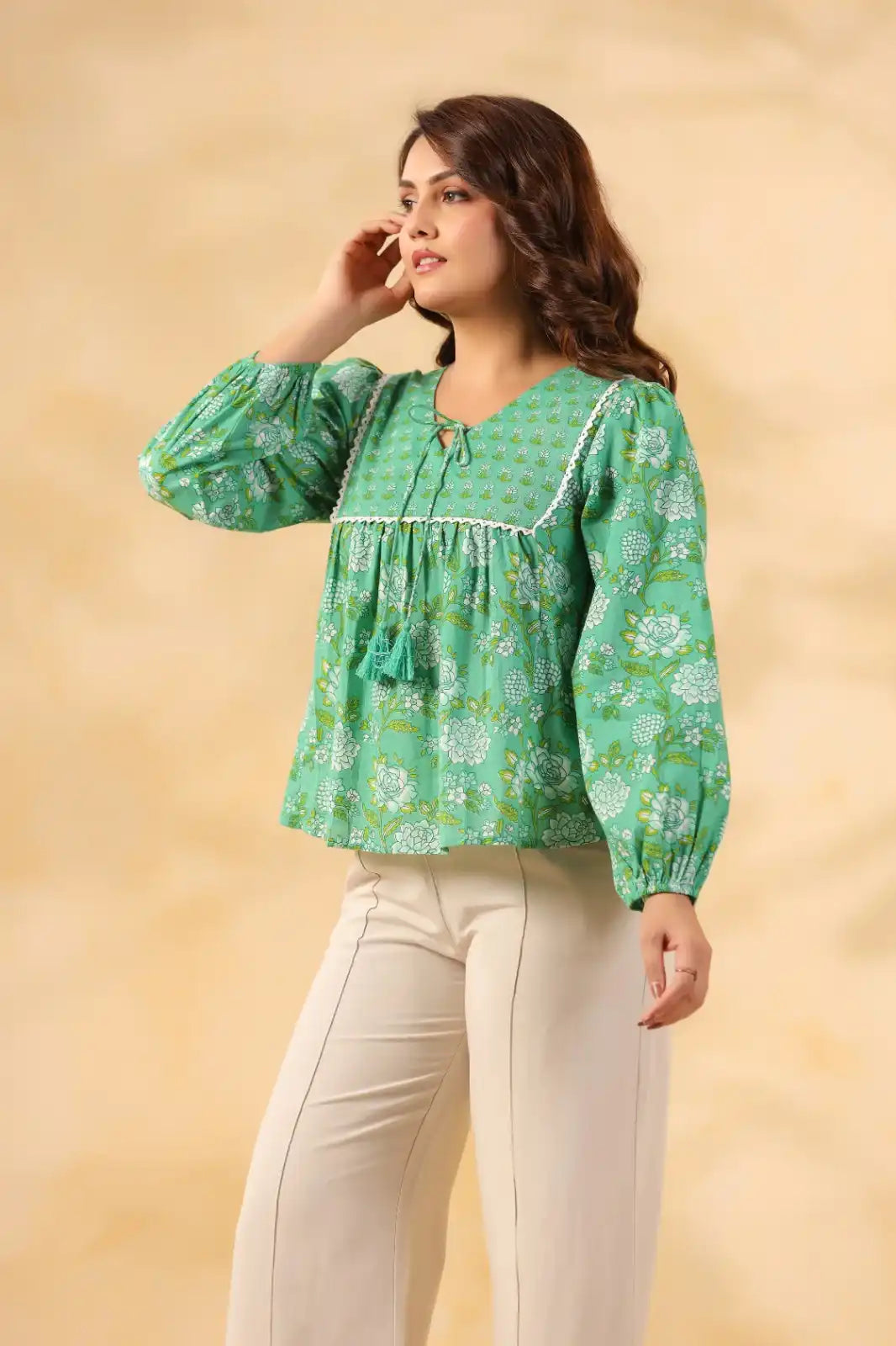 Green floral print cotton kurta with puff sleeves and tassel detail, paired with cream pants for women
