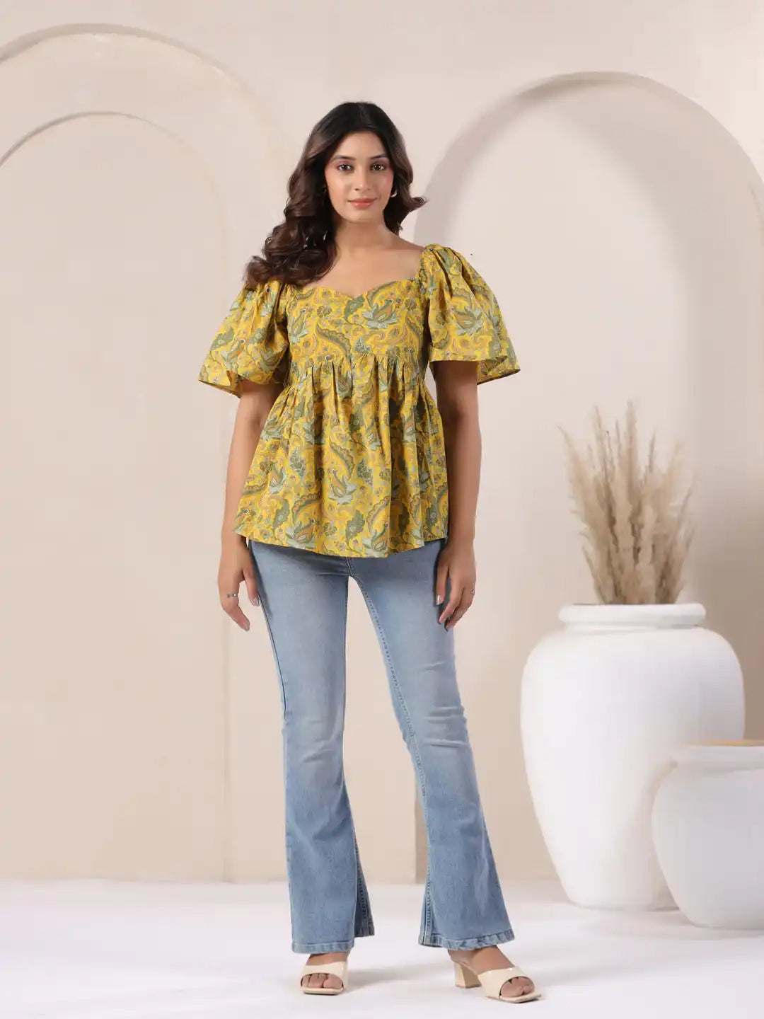 Yellow paisley print peplum top with puff sleeves, paired with blue flared jeans for casual wear